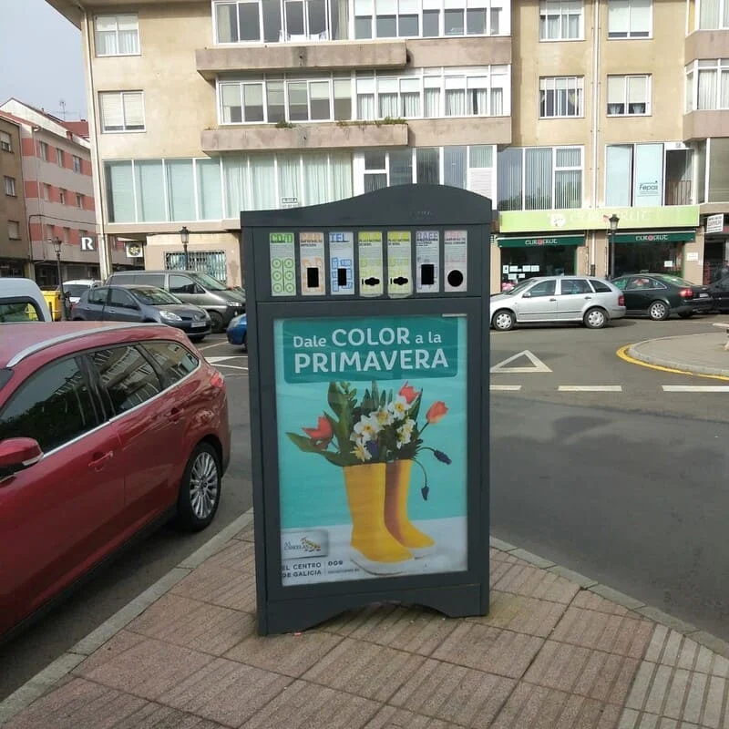 Minipunto de Macane con un cartel publicitario en una plaza de Sigüeiro